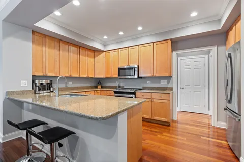 a kitchen with stainless steel appliances granite countertop a refrigerator and a stove