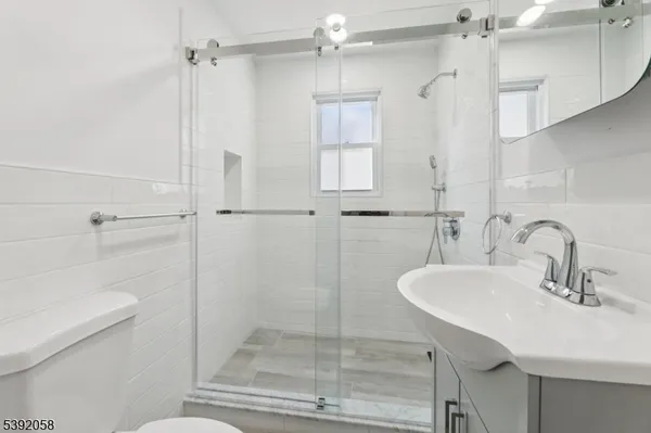 a bathroom with a sink a toilet and shower