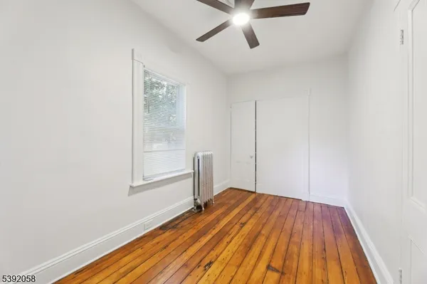 a view of a room with wooden floor closet and windows
