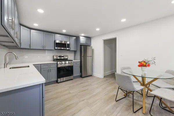 a kitchen with granite countertop a sink cabinets and stainless steel appliances