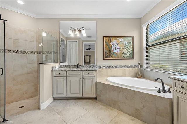 a bathroom with a tub sink and mirror