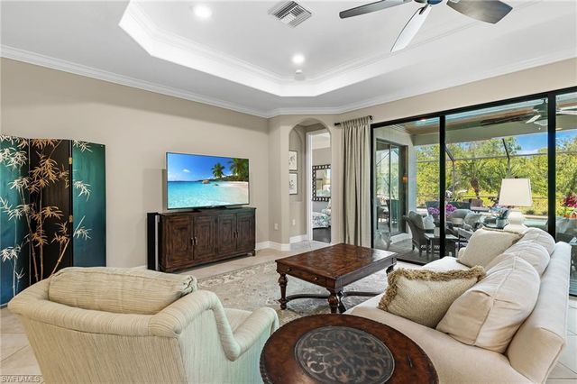 a living room with furniture a large window and a flat screen tv