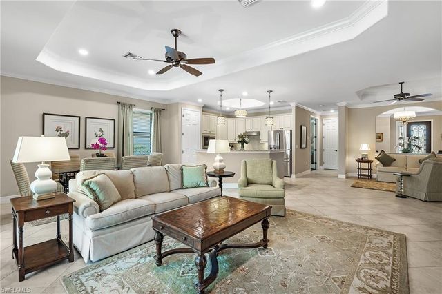 a living room with furniture and a view of kitchen