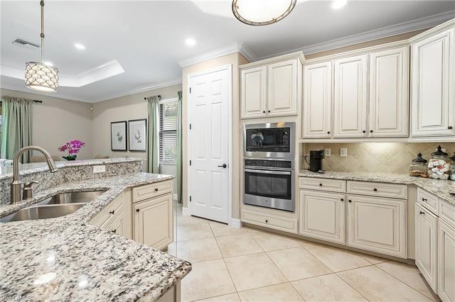 a kitchen with a sink stove and white cabinets
