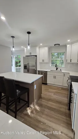 a large kitchen with kitchen island a sink stainless steel appliances and cabinets