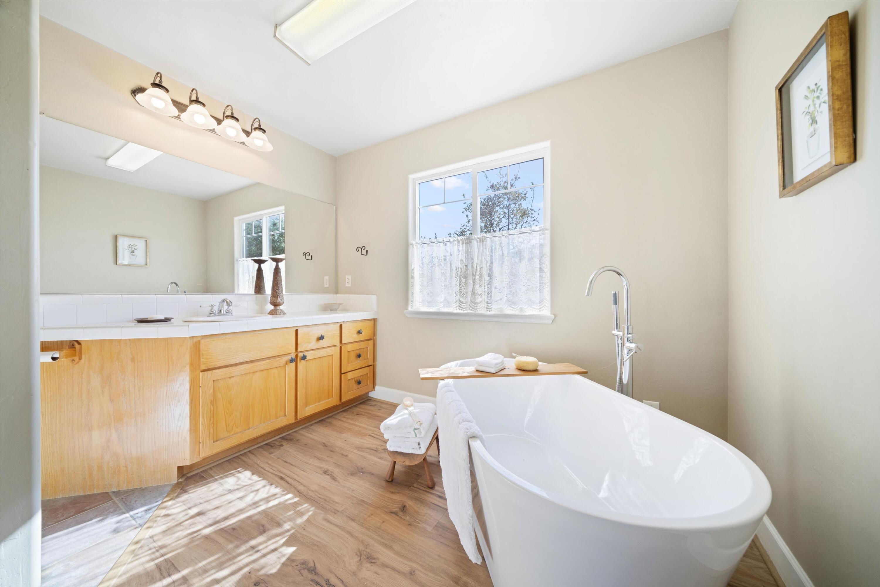21605 Quail Springs Road Tehachapi, CA 93561 - Photo 18 of 35 a spacious bathroom with a double vanity sink a mirror and a bathtub
