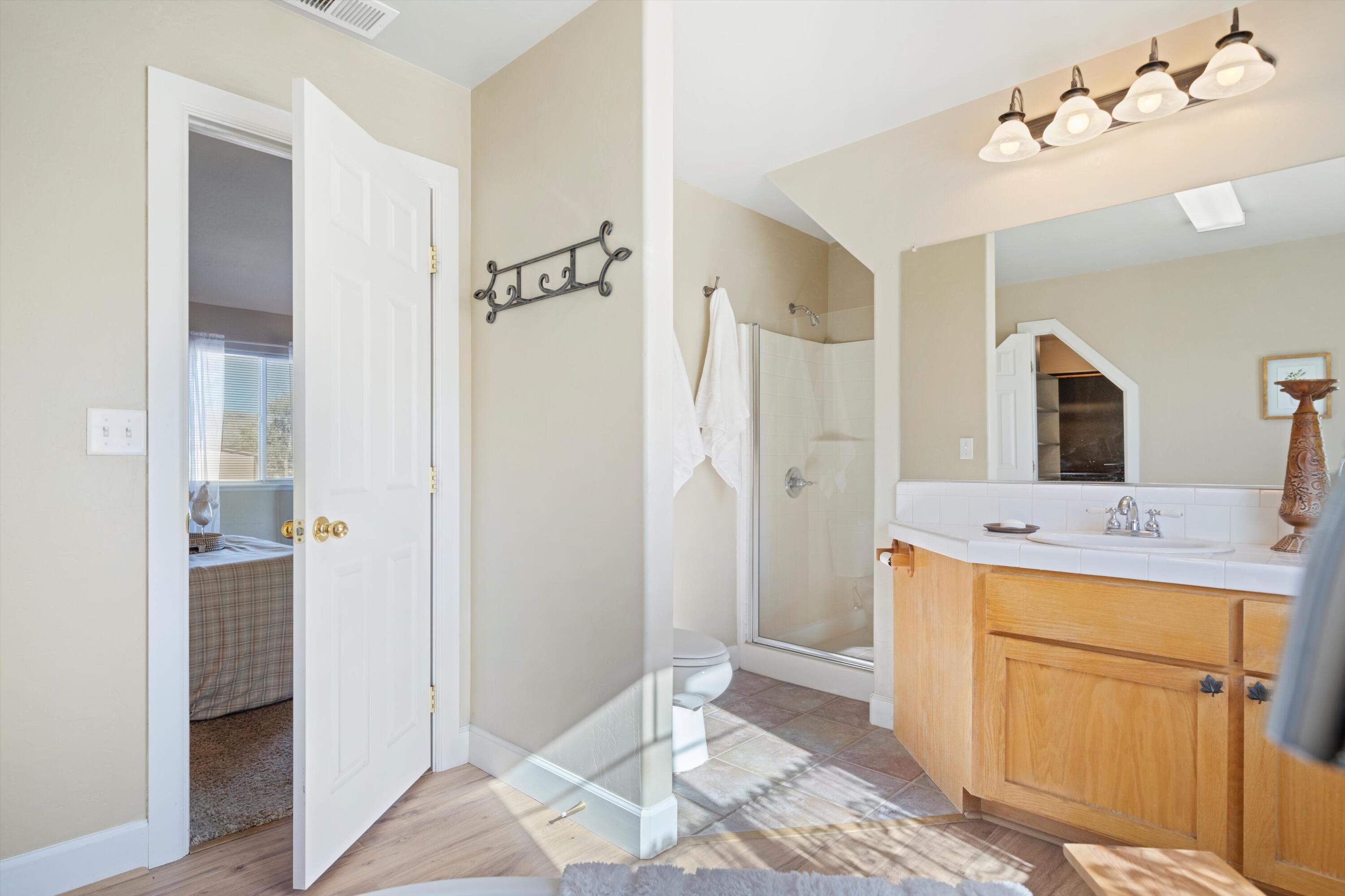 21605 Quail Springs Road Tehachapi, CA 93561 - Photo 19 of 35 a spacious bathroom with a shower sink and mirror