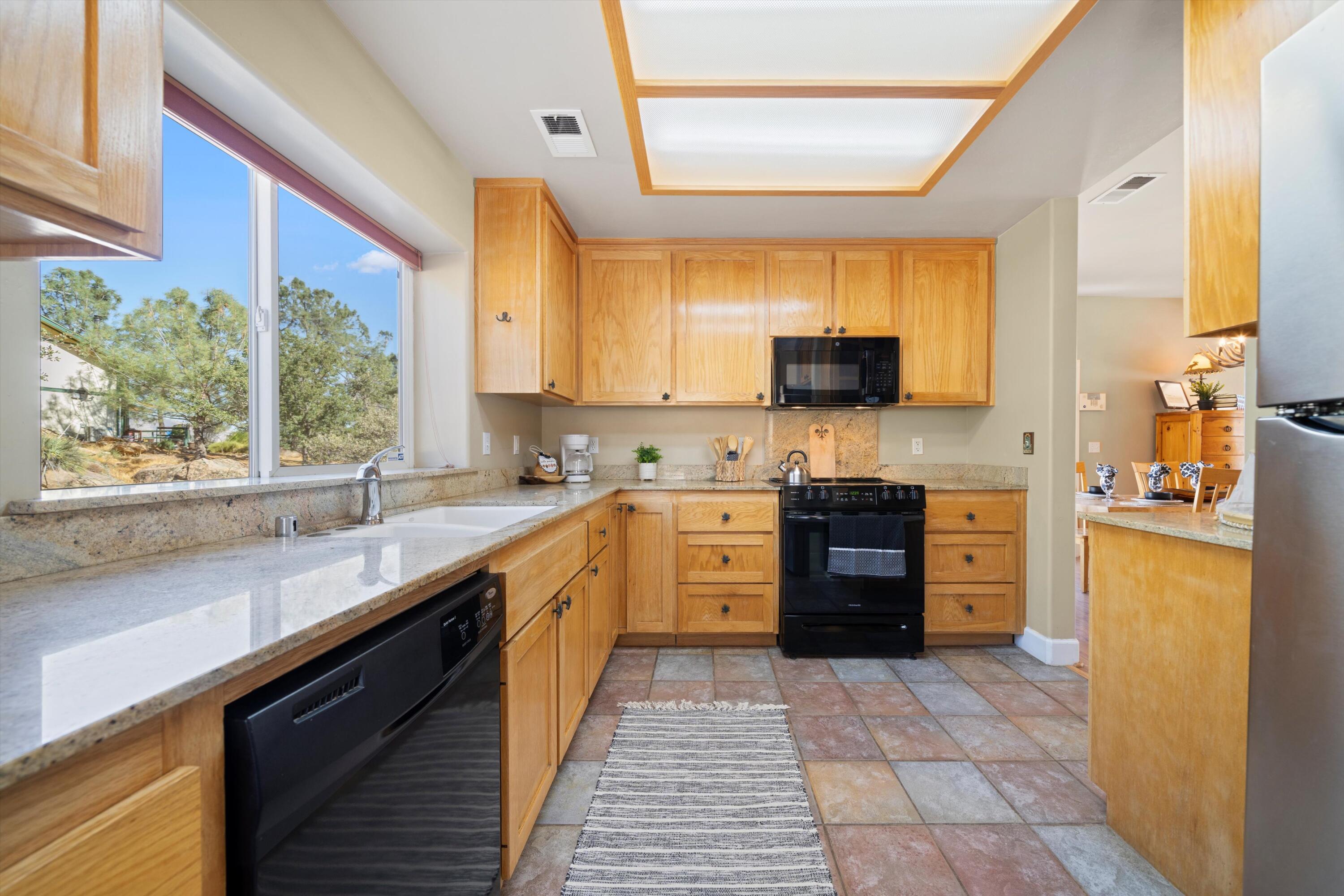 21605 Quail Springs Road Tehachapi, CA 93561 - Photo 10 of 35 a kitchen with stainless steel appliances a stove sink and cabinets