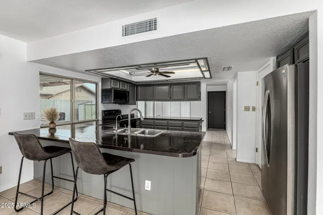 a kitchen with stainless steel appliances a table a chair a stove a chimney and a window