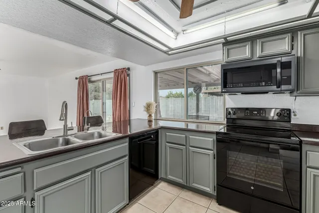 a large kitchen with stainless steel appliances granite countertop a stove and a sink