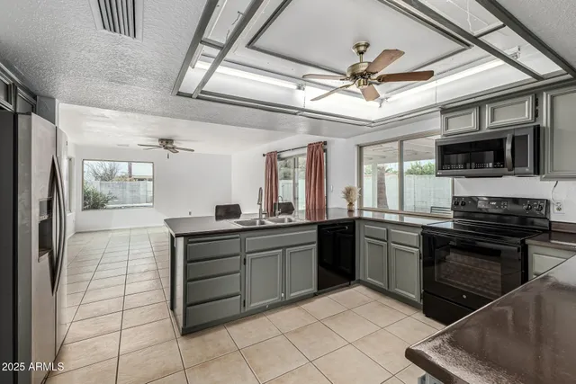a kitchen with stainless steel appliances kitchen island granite countertop a refrigerator and a sink
