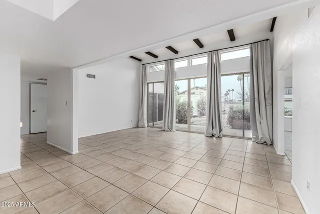 a view of empty room with wooden floor and door