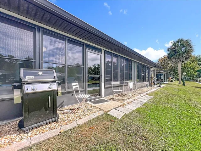 a patio with a table and chairs and potted plants