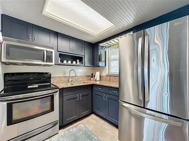 a kitchen with stainless steel appliances granite countertop a stove microwave and refrigerator