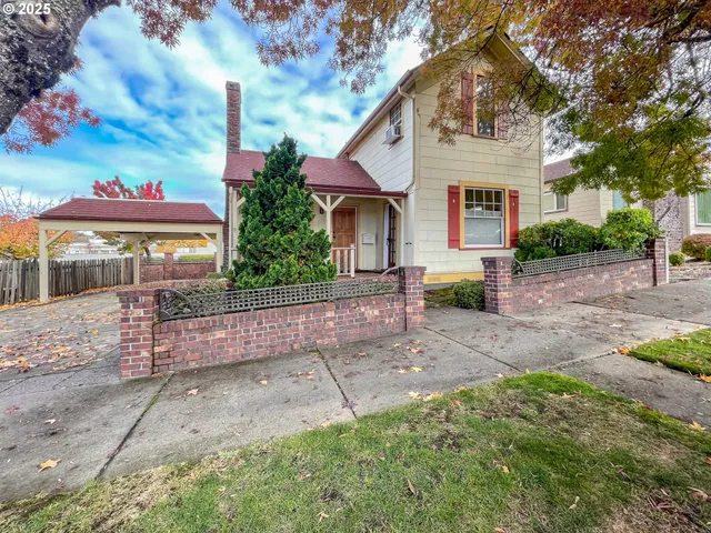 a view of a white house with a yard and plants
