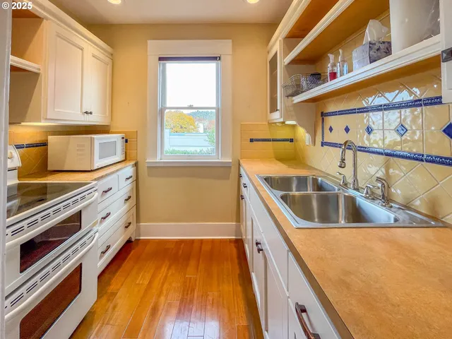 a kitchen with stainless steel appliances a stove a sink and a microwave