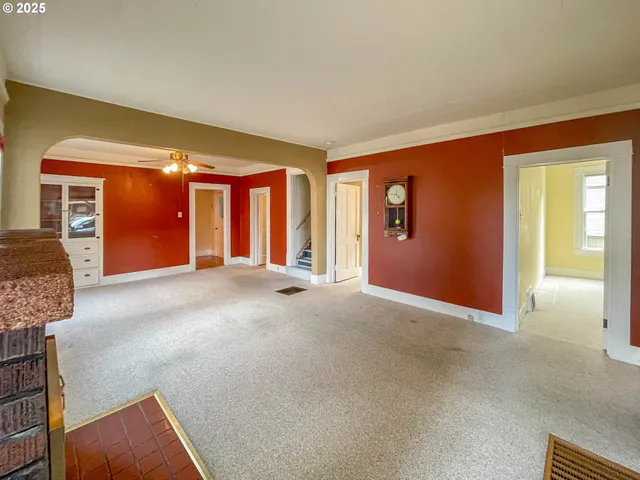 a view of an empty room with window and stairs