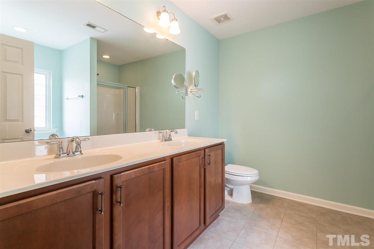 1100 Ileagnes Road Raleigh, NC 27603 - Photo 14 of 22 a bathroom with a sink a toilet a mirror and vanity