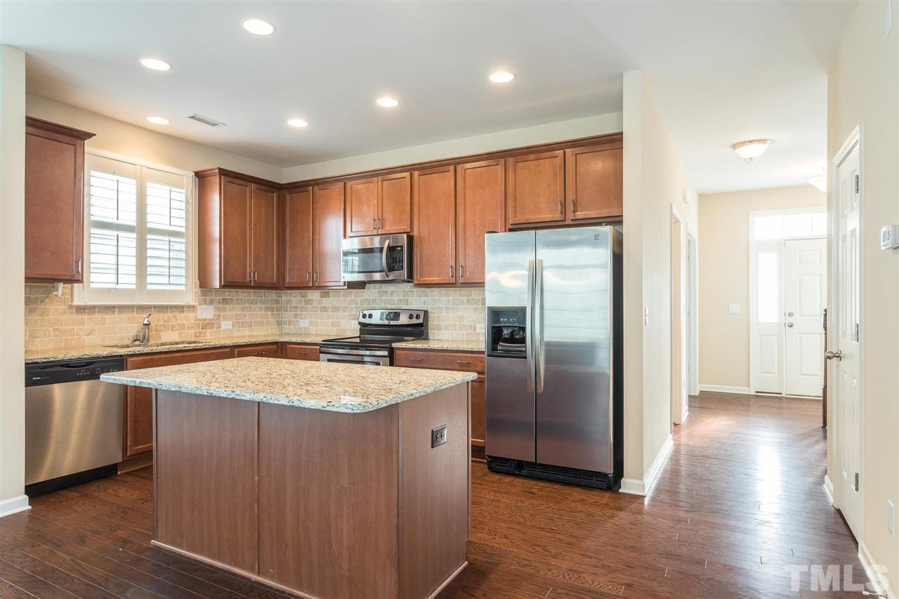 1100 Ileagnes Road Raleigh, NC 27603 - Photo 7 of 22 a kitchen with stainless steel appliances granite countertop a refrigerator a sink a stove a microwave and island
