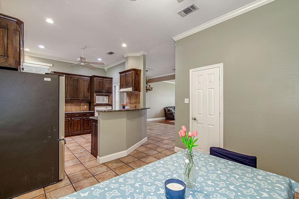 9801 Bellechase Road Granbury, TX 76049 - Photo 13 of 40 a living room with stainless steel appliances kitchen island granite countertop furniture a rug and a window