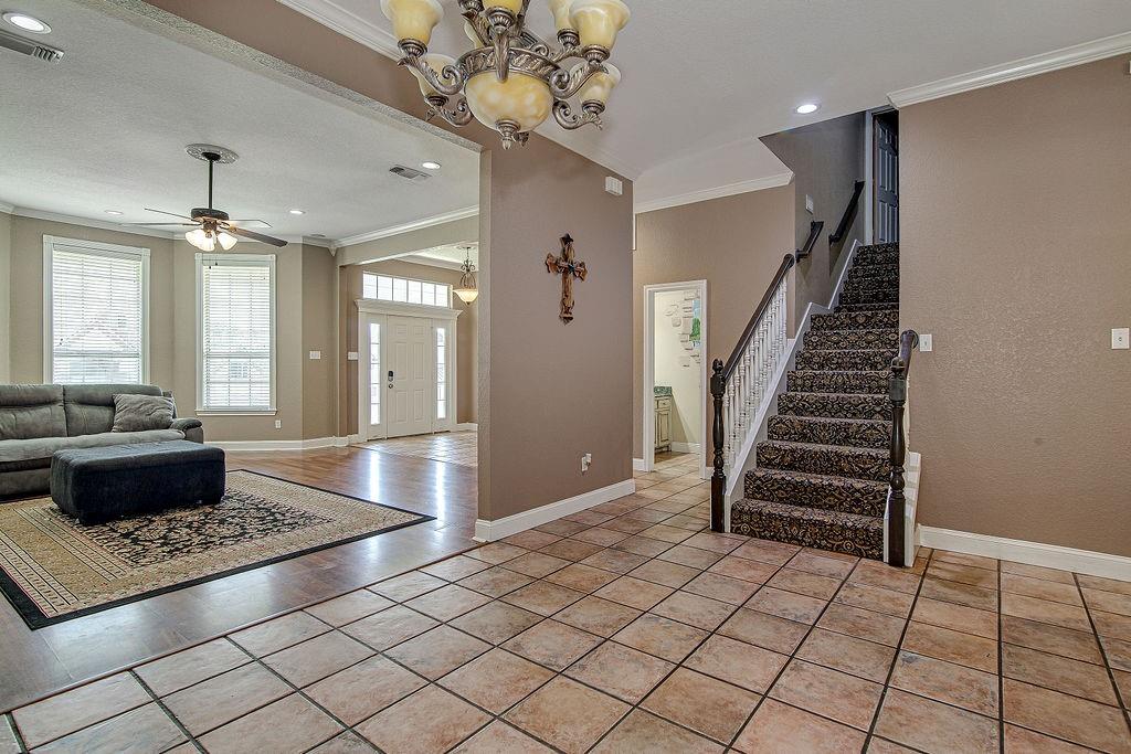 9801 Bellechase Road Granbury, TX 76049 - Photo 15 of 40 a living room with a couch and a chandelier