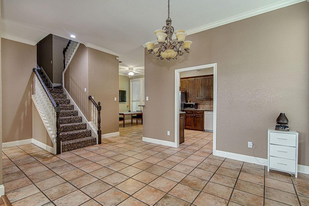 9801 Bellechase Road Granbury, TX 76049 - Photo 16 of 40 an entryway with a stove and a chandelier