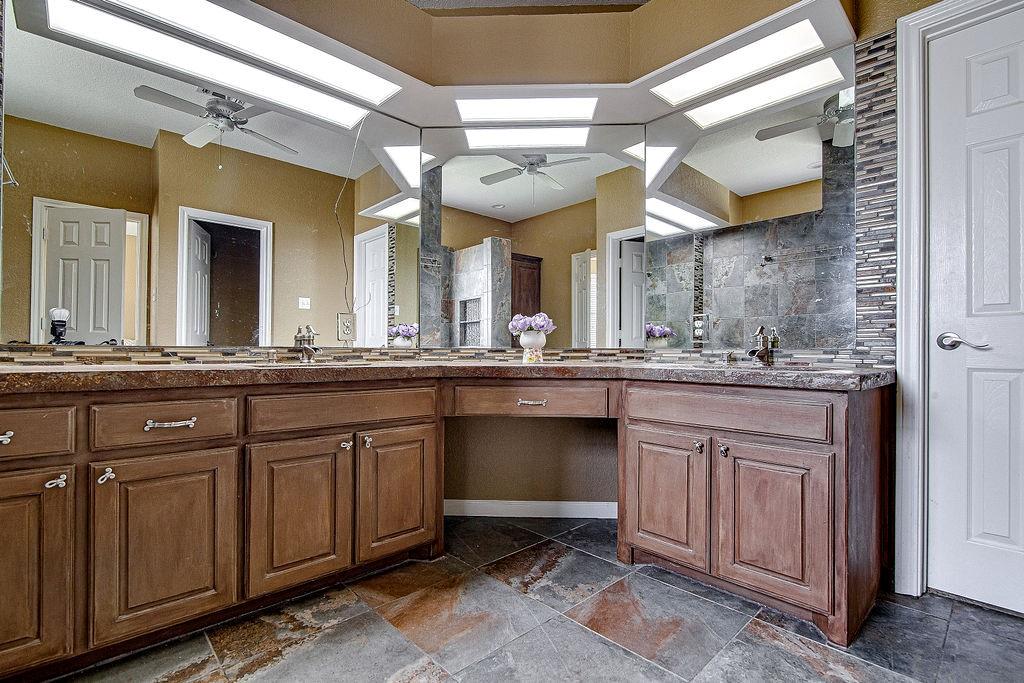9801 Bellechase Road Granbury, TX 76049 - Photo 31 of 40 a bathroom with a sink and a large mirror