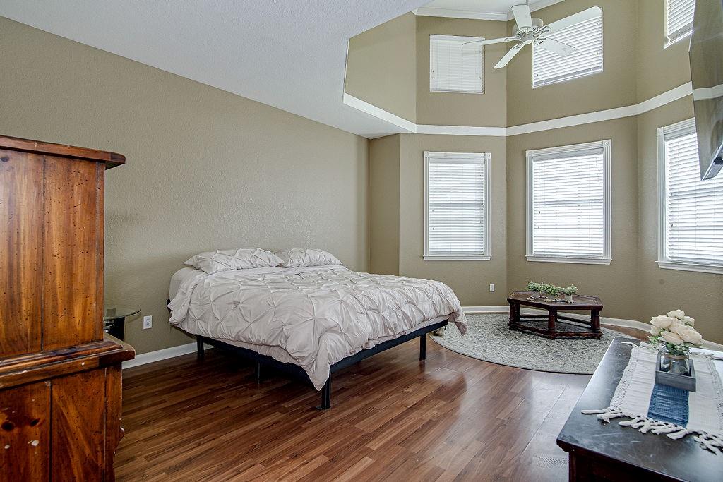 9801 Bellechase Road Granbury, TX 76049 - Photo 37 of 40 a spacious bedroom with a bed and wooden floor