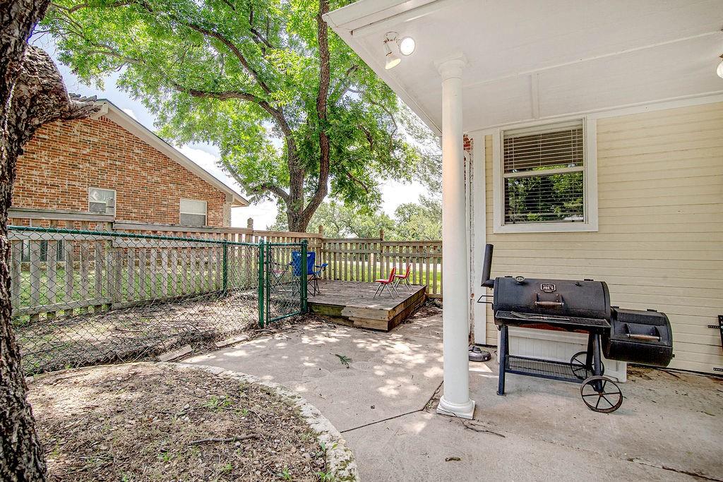 9801 Bellechase Road Granbury, TX 76049 - Photo 6 of 40 a view of a backyard with a wooden fence and a bench