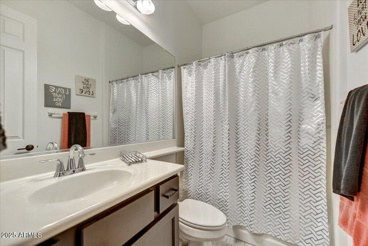 17943 East Silver Sage Lane Rio Verde, AZ 85263 - Photo 21 of 66 a bathroom with a sink a toilet and shower curtain
