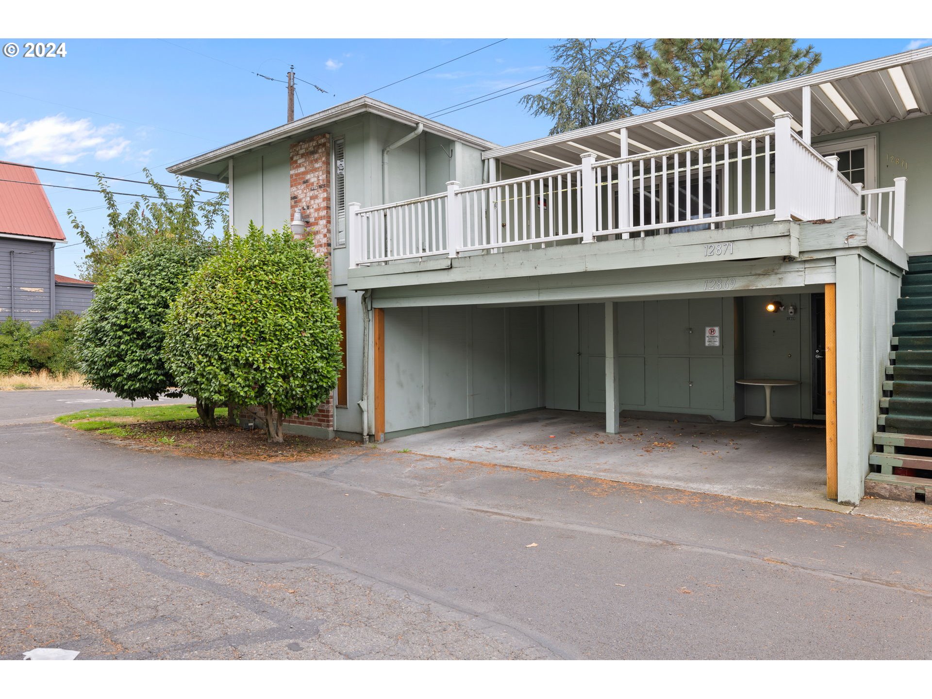 12871 Southeast Stark Street, Unit A16 Portland, OR 97233 - Photo 1 of 20 a front view of a house with a garden and garage