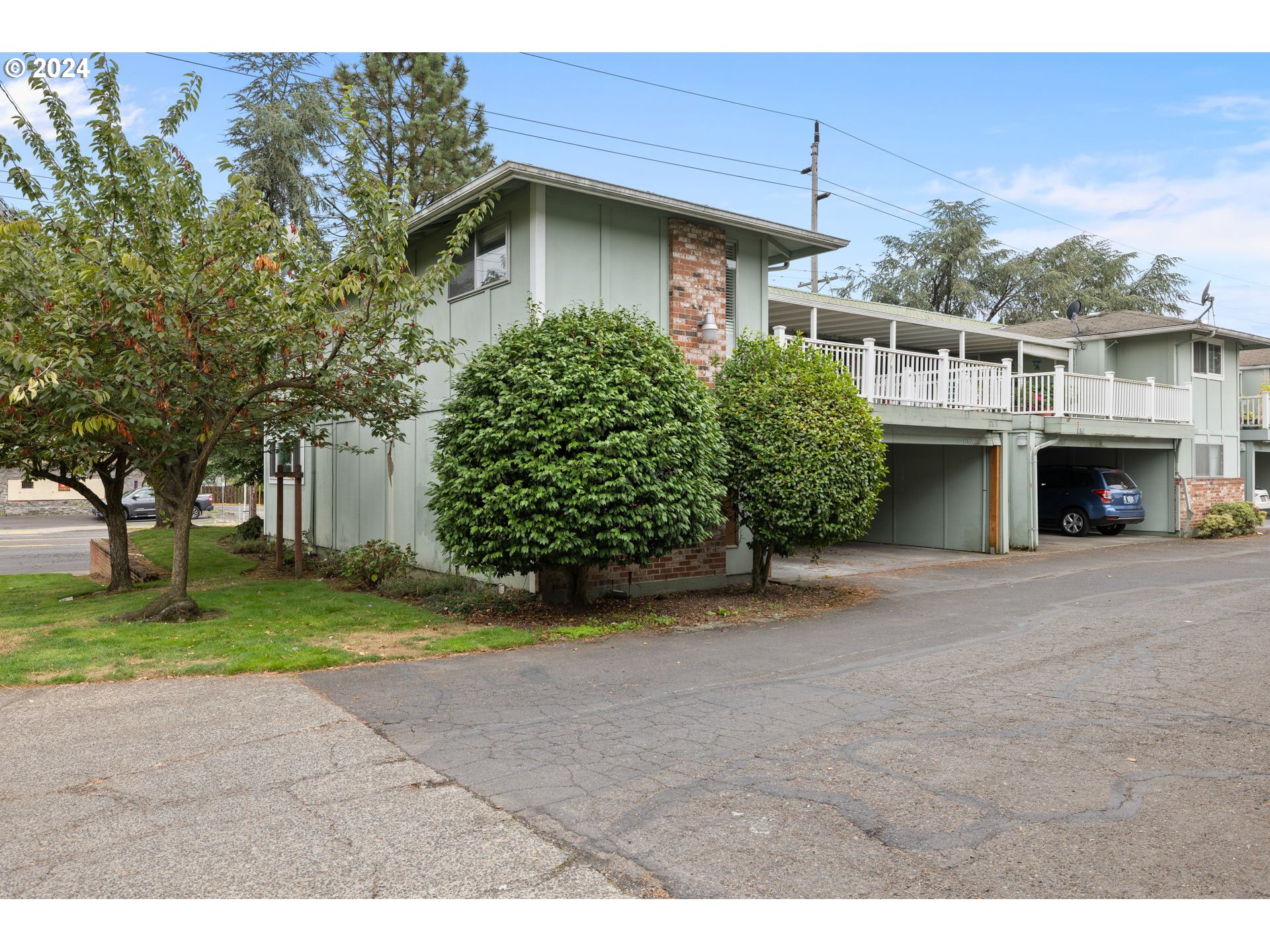 12871 Southeast Stark Street, Unit A16 Portland, OR 97233 - Photo 2 of 20 a front view of a house with a yard and garage