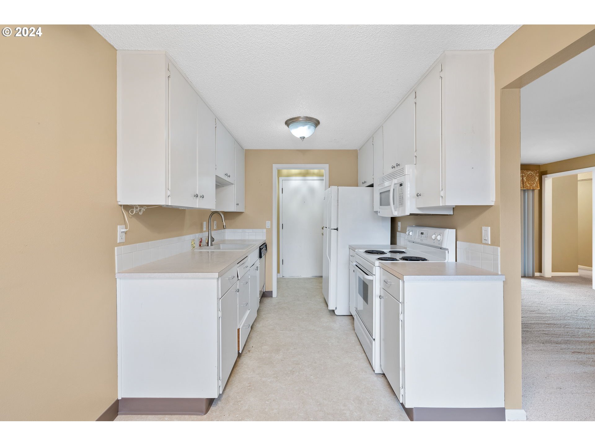 12871 Southeast Stark Street, Unit A16 Portland, OR 97233 - Photo 6 of 20 a kitchen with stainless steel appliances a sink a stove a refrigerator cabinets and a window