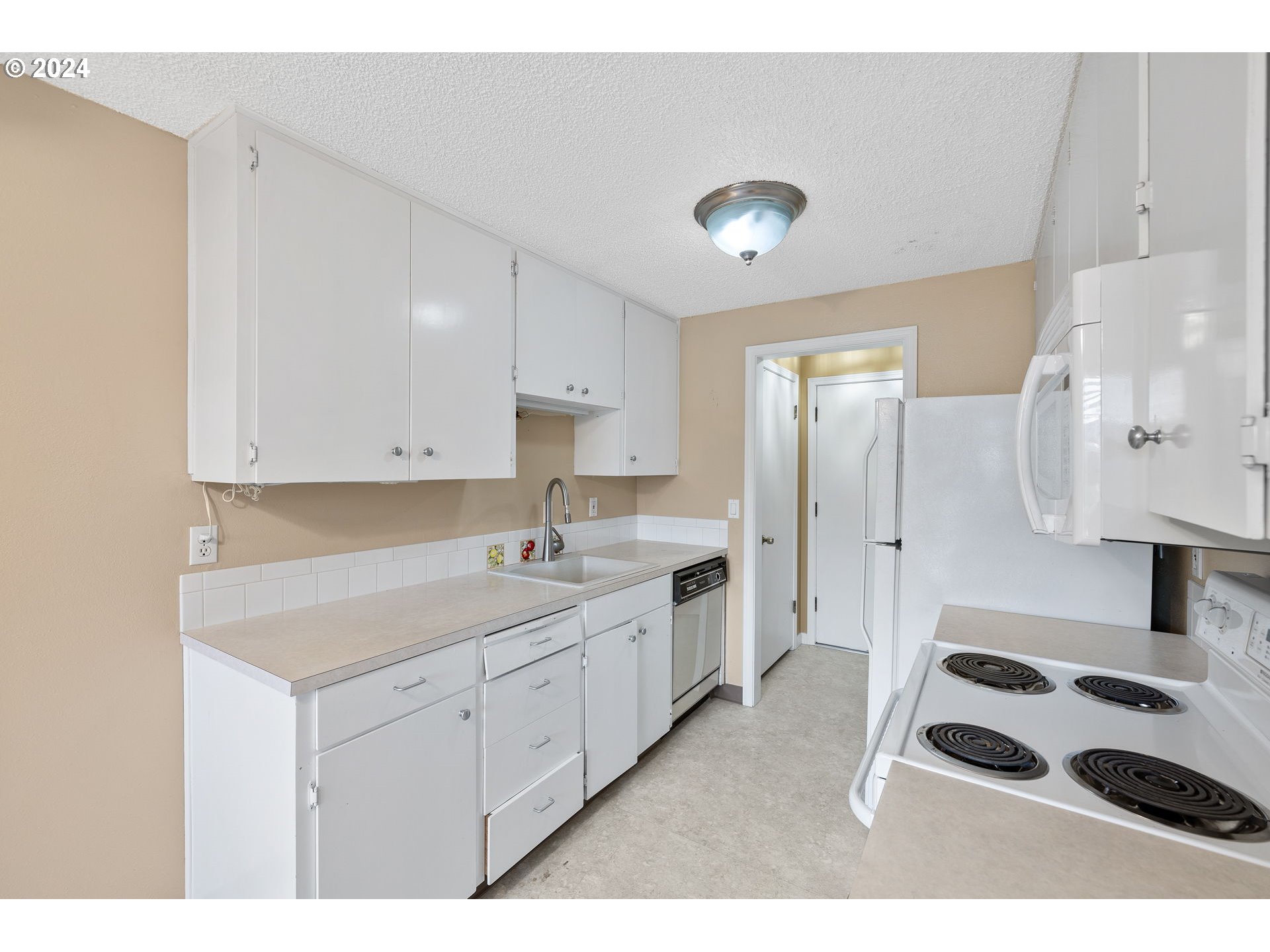 12871 Southeast Stark Street, Unit A16 Portland, OR 97233 - Photo 7 of 20 a kitchen with a sink appliances and cabinets