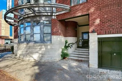 a living room with stainless steel appliances furniture a flat screen tv and a refrigerator