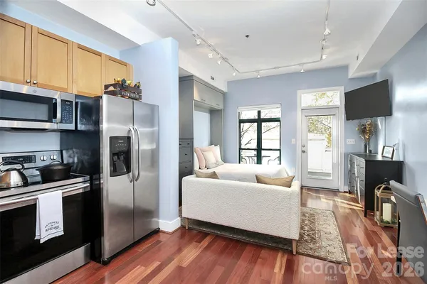 a kitchen with stainless steel appliances kitchen island granite countertop a stove a sink and a refrigerator