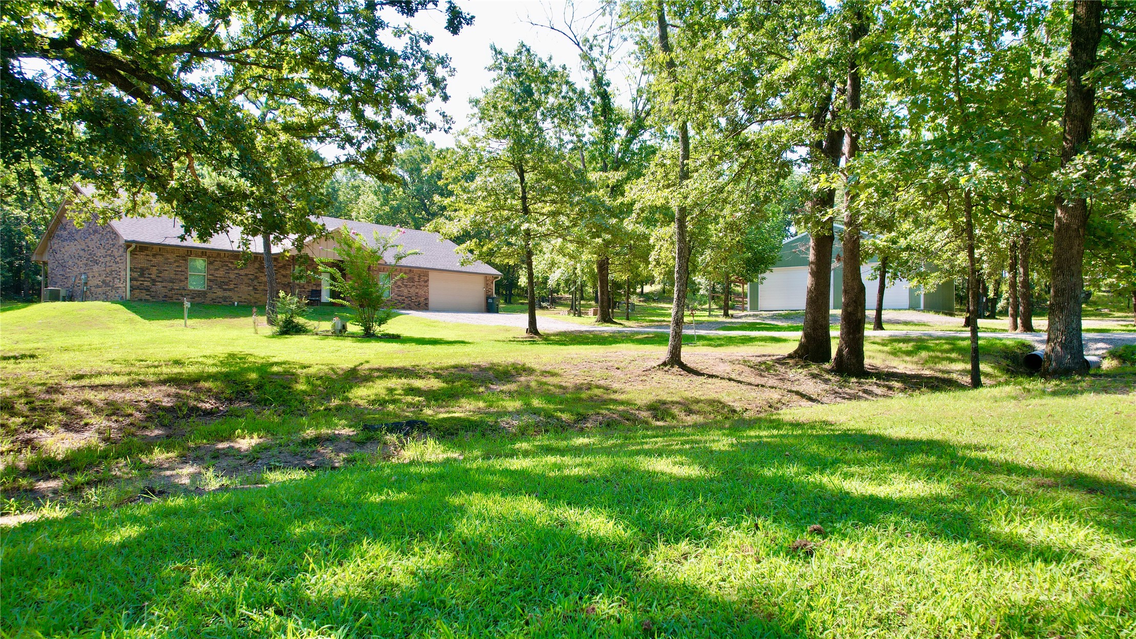 114495 South 4296th Road Porum, OK 74455 - Photo 54 of 59 Expansive green lawn with mature trees and a long driveway leading to a brick-clad residence