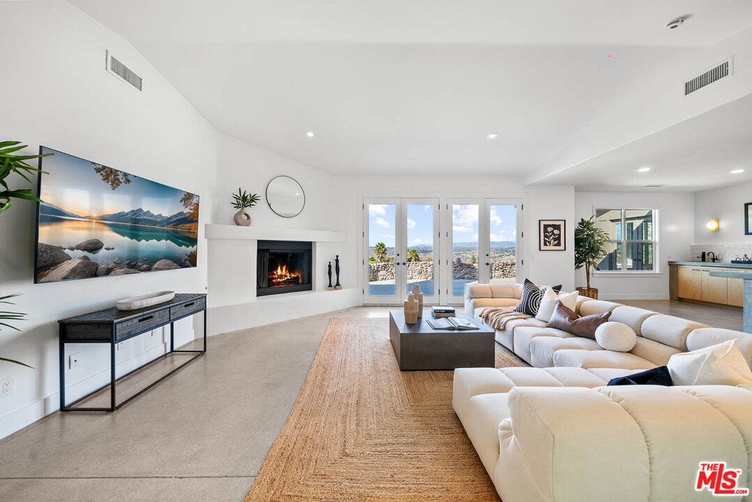 32070 Vía Vera Bonsall, CA 92003 - Photo 30 of 75 a living room with furniture flat screen tv and a fireplace