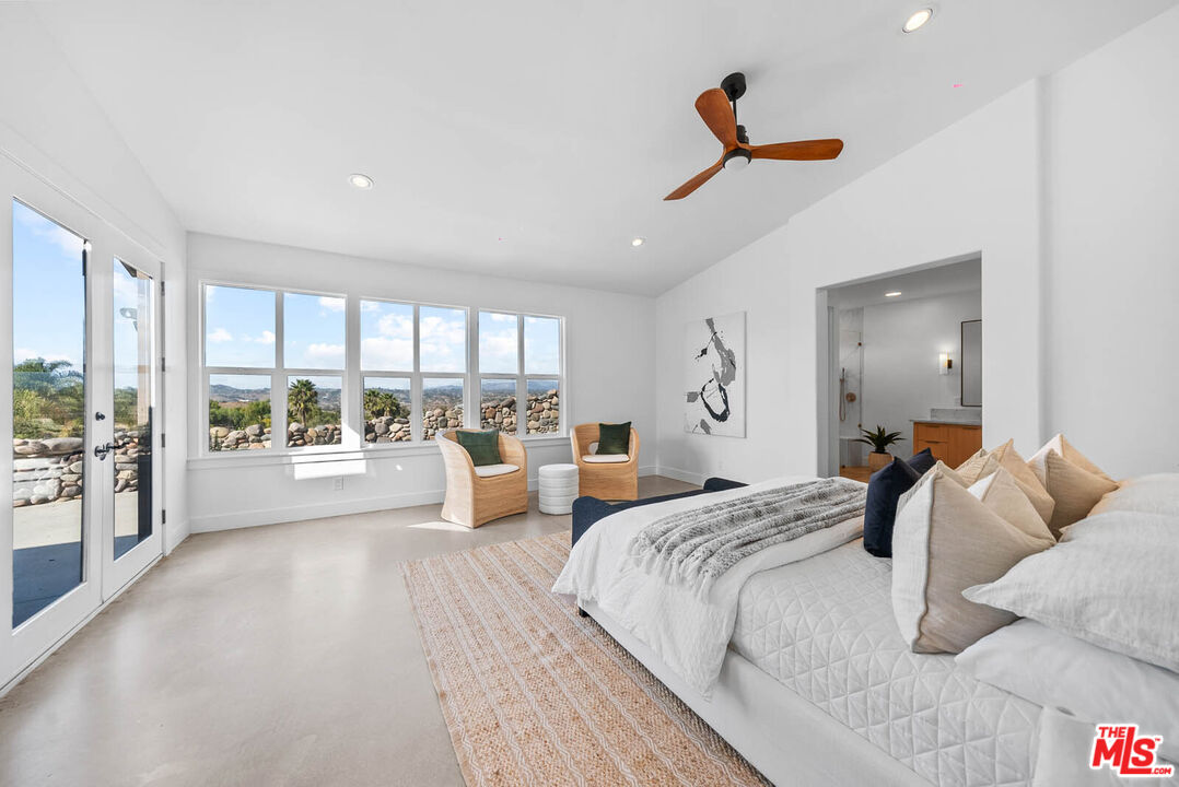 32070 Vía Vera Bonsall, CA 92003 - Photo 33 of 75 a spacious bedroom with a large bed and a large window