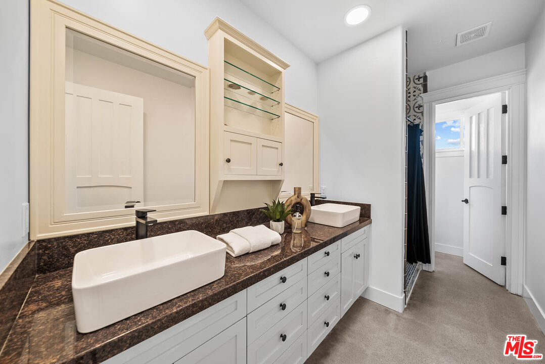 32070 Vía Vera Bonsall, CA 92003 - Photo 42 of 75 a bathroom with a double vanity sink and mirror