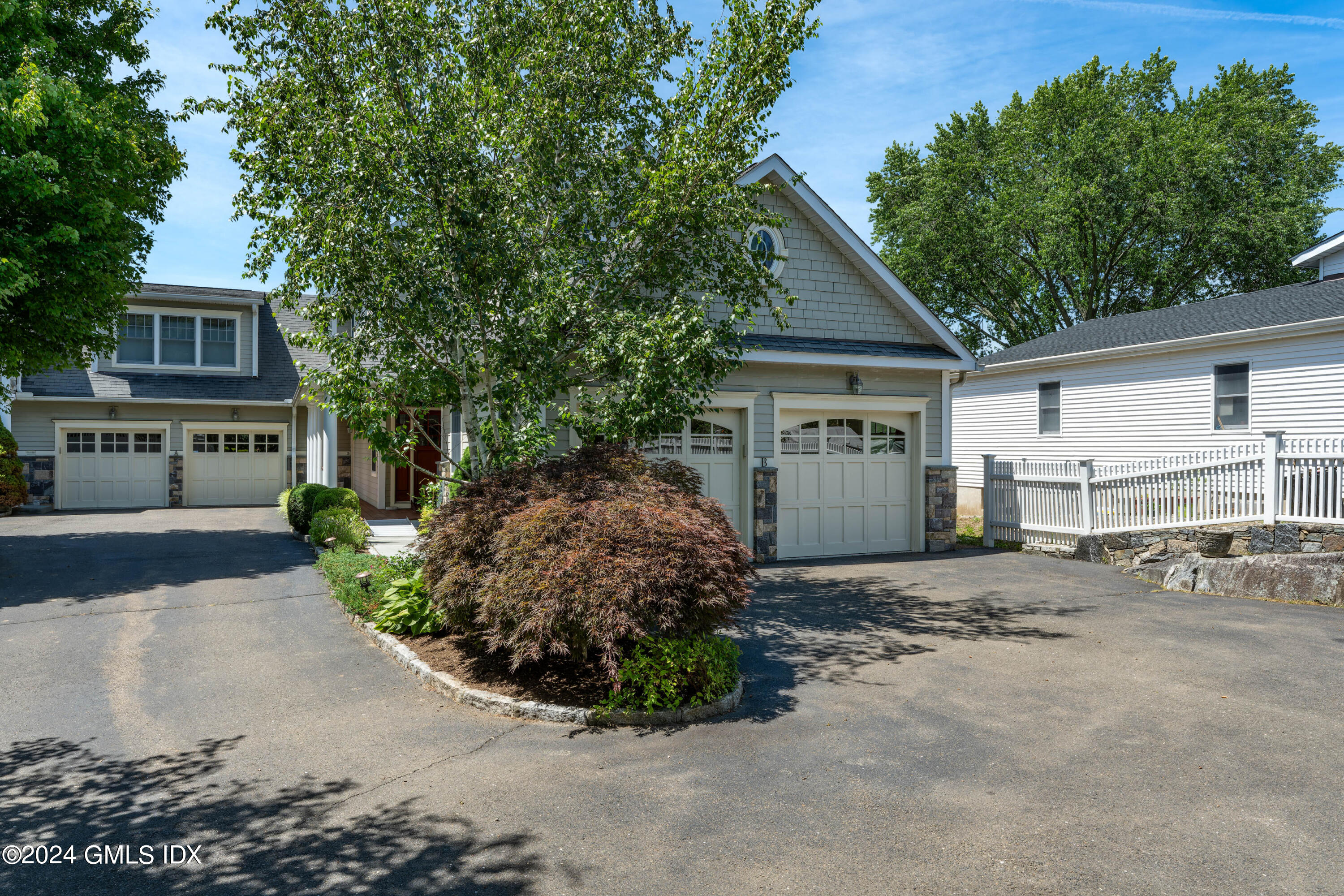 a view of a house with a yard and large tree