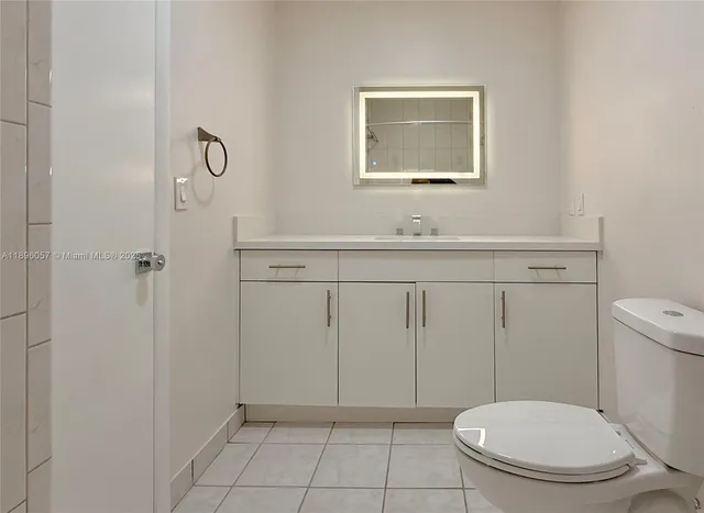 a bathroom with a toilet a sink and mirror