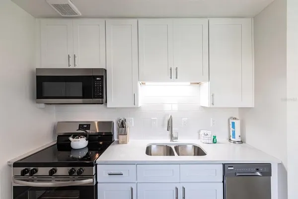 a kitchen with a sink stove and cabinets