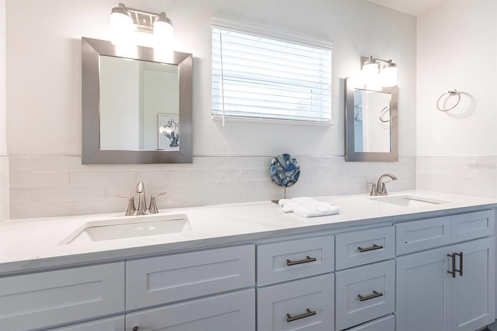 6020 Midnight Pass Road, Unit 5 Sarasota, FL 34242 - Photo 15 of 22 a bathroom with double sink and a mirror