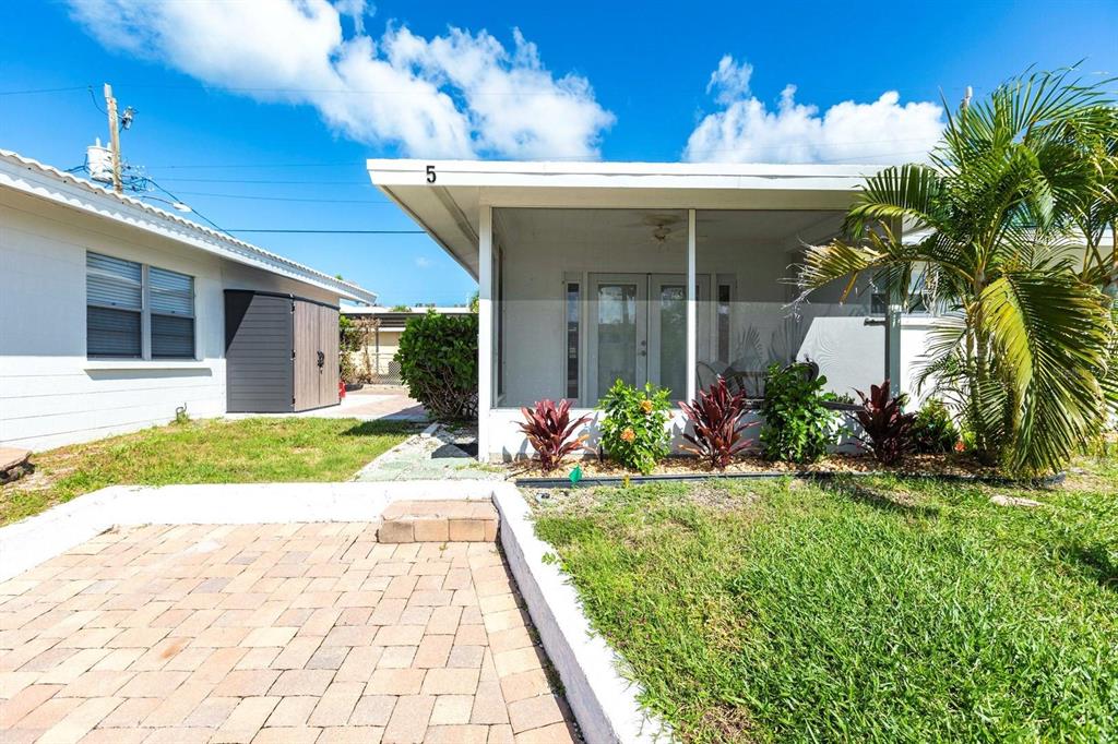 6020 Midnight Pass Road, Unit 5 Sarasota, FL 34242 - Photo 2 of 22 a front view of a house with a yard and potted plants