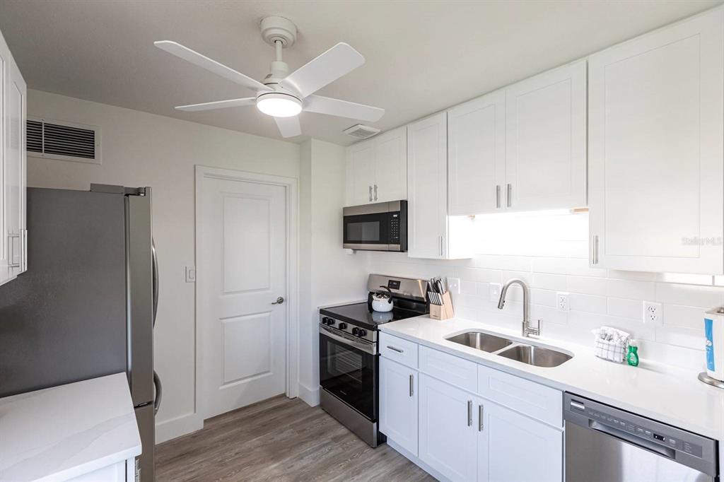 6020 Midnight Pass Road, Unit 5 Sarasota, FL 34242 - Photo 5 of 22 a kitchen with a sink a stove and refrigerator