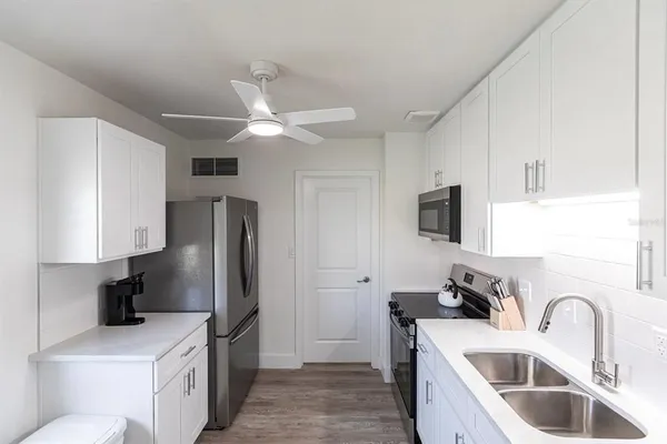 a kitchen with stainless steel appliances granite countertop a sink stove and refrigerator