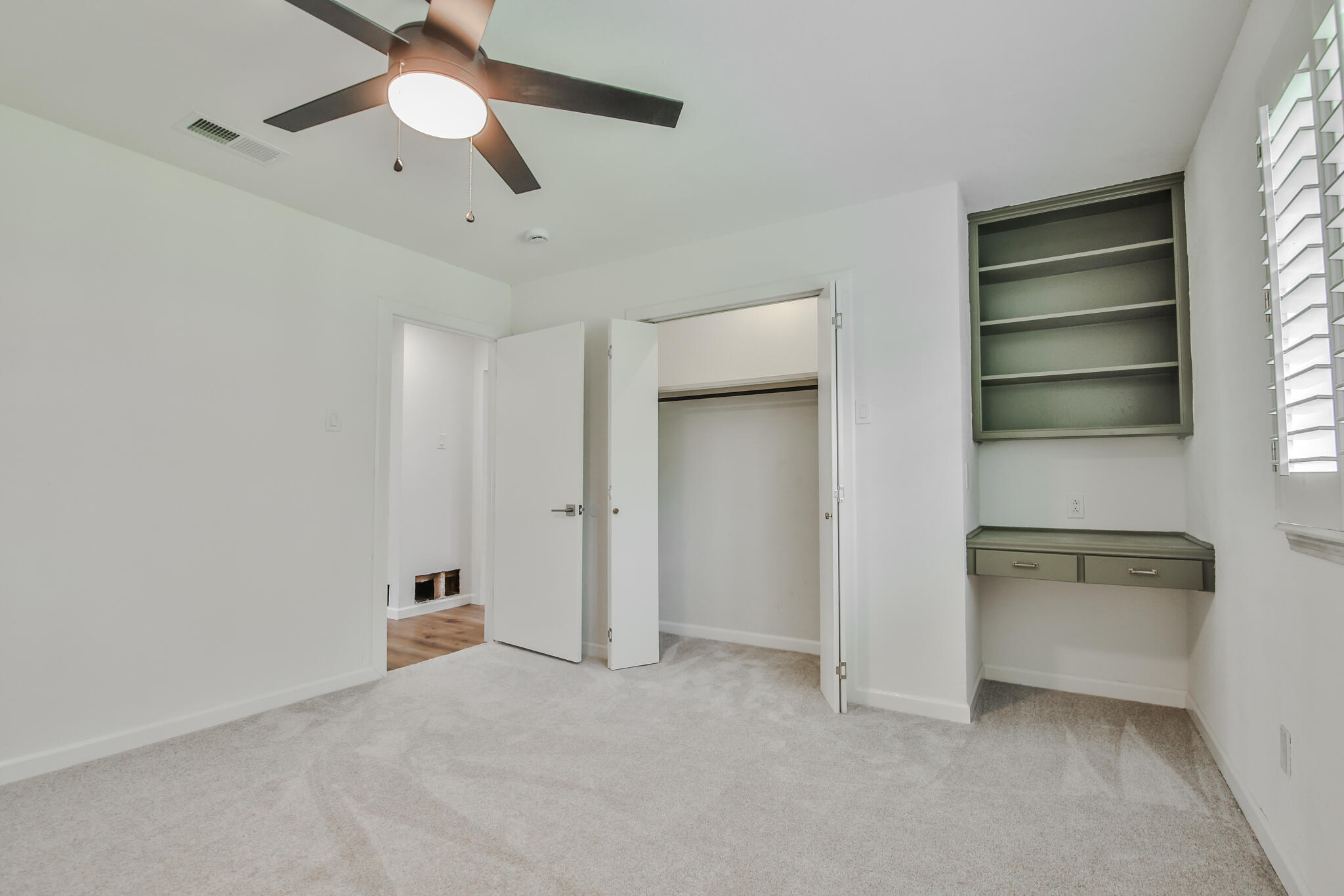 2620 78th Street Lubbock, TX 79423 - Photo 17 of 27 a view of an empty room with a ceiling fan and window