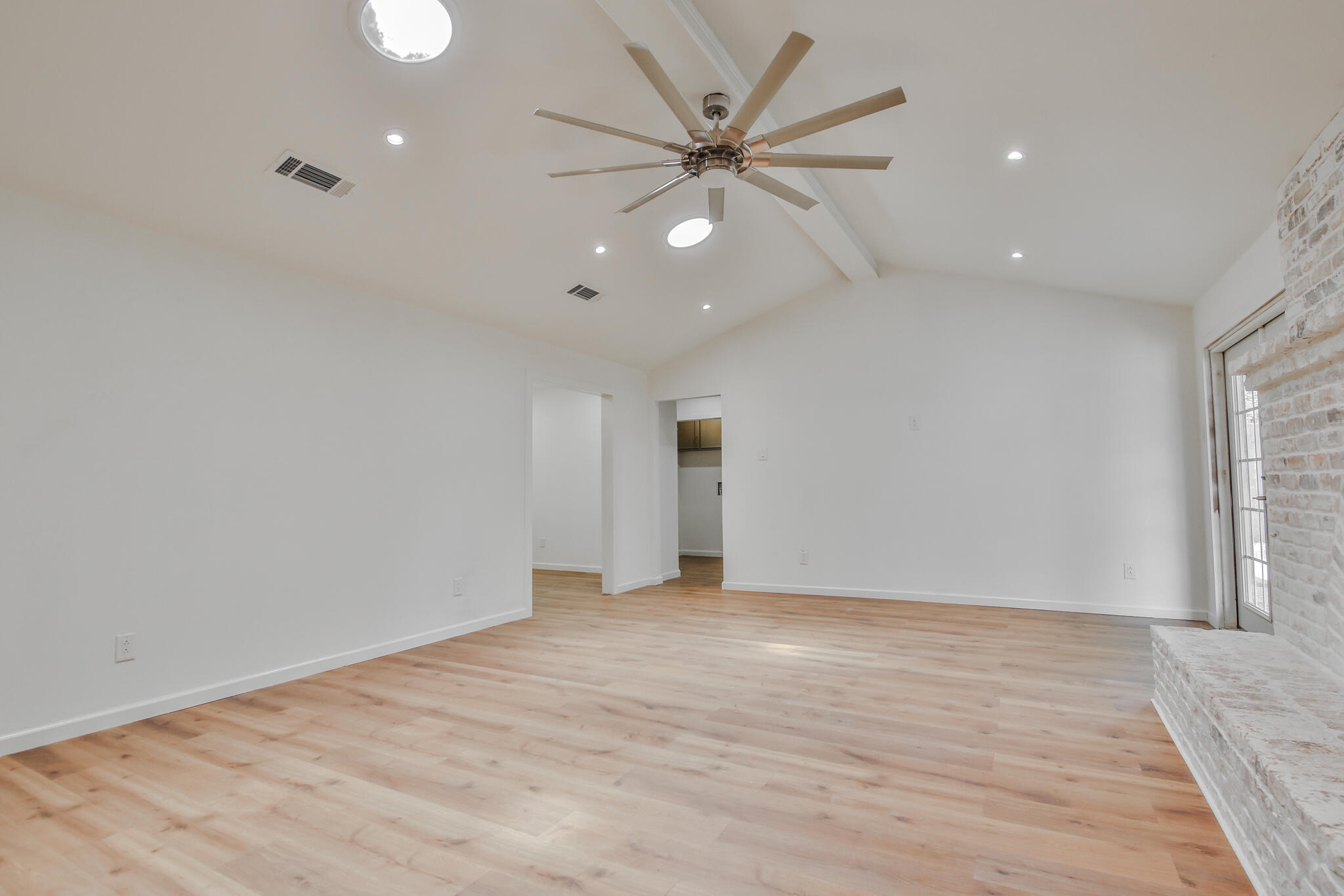2620 78th Street Lubbock, TX 79423 - Photo 6 of 27 an empty room with wooden floor and a ceiling fan