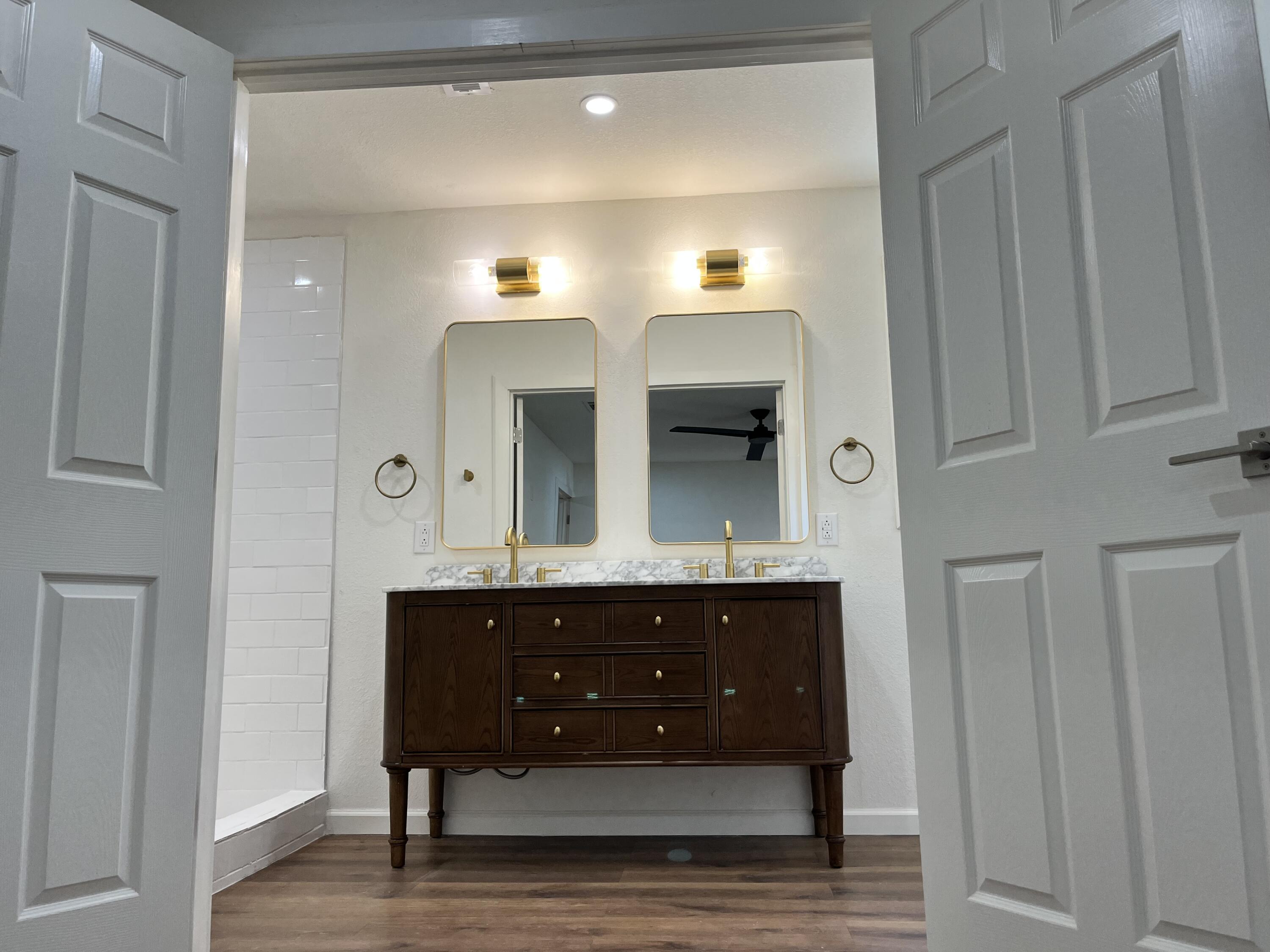 2620 78th Street Lubbock, TX 79423 - Photo 10 of 27 a spacious bathroom with a double vanity sink and a mirror